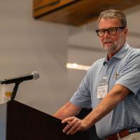Michael Hudkins speaking to a group of people while standing at a podium