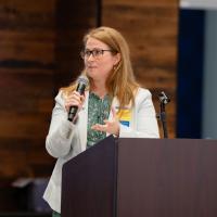 A female doctor speaks from a podium