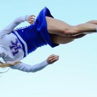 Allie flies through the air as part of a cheerleading toss.