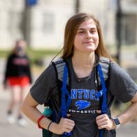 Allison is walking around the UK campus in her Kentucky Gymnastics shirt, carrying her backpack.