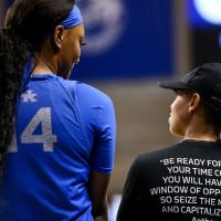 A photo of Amber and a player with their backs to the camera, talking and smiling before a game. Amber’s shirt says “Be ready for when your time comes. You will have that window of opportunity.”