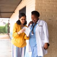 Dr. Shenoi reviews a brochure with a doctor in Rwanda.