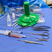 A table full of different medical tools used for surgery, located in an operating room.