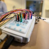 The Brain Computer Interface, a tool used to record brainwaves, with multiple wires of different colors attached to it.