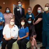 Ten people who work for the Environmental Services Department posing together for a picture while all wearing face masks.