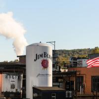 A photo of the James B. Beam Distillery during golden hour. A silo with the company’s logo is in the middle of the frame.