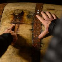 A photo of Fred and DeeAnn’s hands on a barrel.