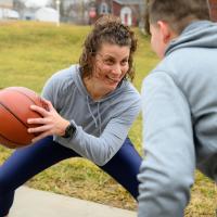 Geri makes a face as she plays one-on-one basketball with her son.