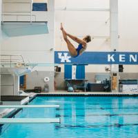 A photo of Jaida mid-dive, her body in the shape of a ‘V’ as she flips backwards into the pool.