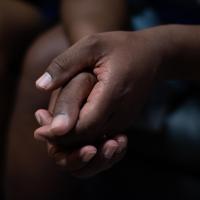 Close-up photo of two hands clasped together.