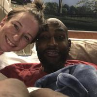 A selfie from Joshua’s hospital bed of him and his wife Jill. Jill is a white woman with brown hair that is tied up in a messy bun. She is wearing a gray shirt with a red collar.