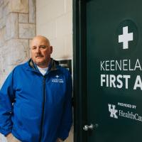 A photo of Matt looking into the camera as he leans against the wall outside of the Keeneland First Aid clinic.
