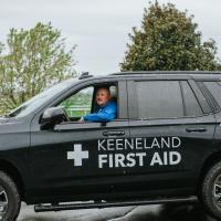 A photo of Matt driving the Keeneland First Aid vehicle with the driver’s side window down and his elbow resting on the door.