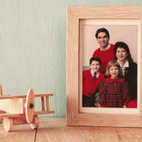 A close-up of a framed photo of the Mynear family posing together.