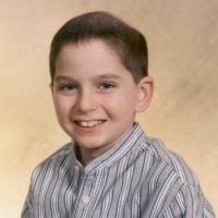 A school photo of Jarrett. He is smiling for the camera in front of a beige background.
