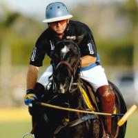 An action shot of Omar riding a horse while playing a polo match.
