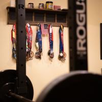 Over a dozen medals hang from the wall in Patty's weight lifting room.