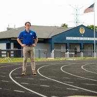 Peter stands outside on the running track at Henry Clay High School.