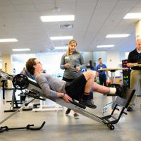 Peter performs his physical therapy exercises while one of his therapists watches.