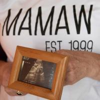Debbie holds a framed photo of the sonograph of her granddaughter.