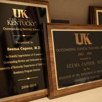 A close up of several award plaques Dr. Capoor has earned.