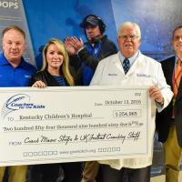 Mark and Chantel Stoops present an oversized check for $254,965 to two doctors from Kentucky Children’s Hospital.