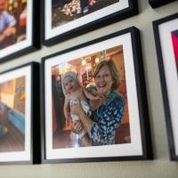 Framed photographs of Suzanne and her grandkids hanging on a wall.