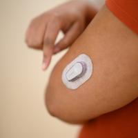 A close-up photo of the glucose monitor on Whitley’s arm.