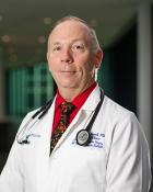 Headshot for Vincent L. Sorrell, MD wearing white coat with stethoscope