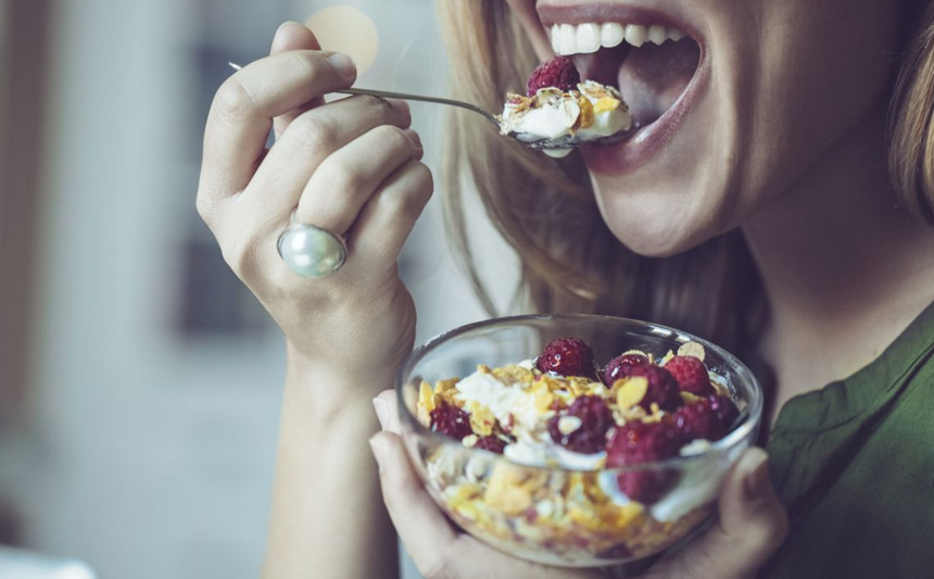 Woman eating cereal with fruit