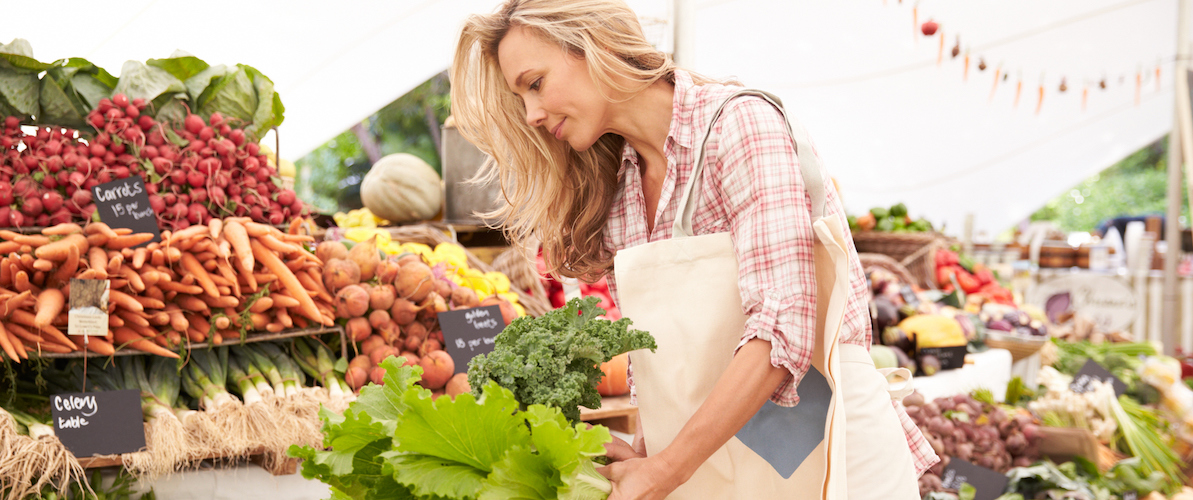 A woman shops for produce at a farmers market.