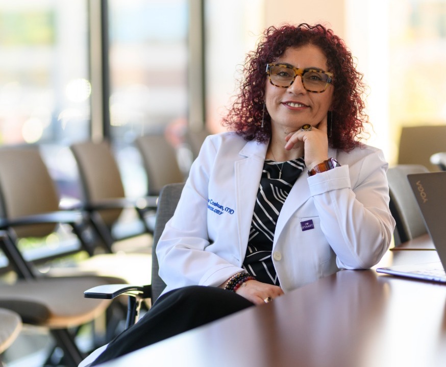 Dr. Coskun sits at conference table