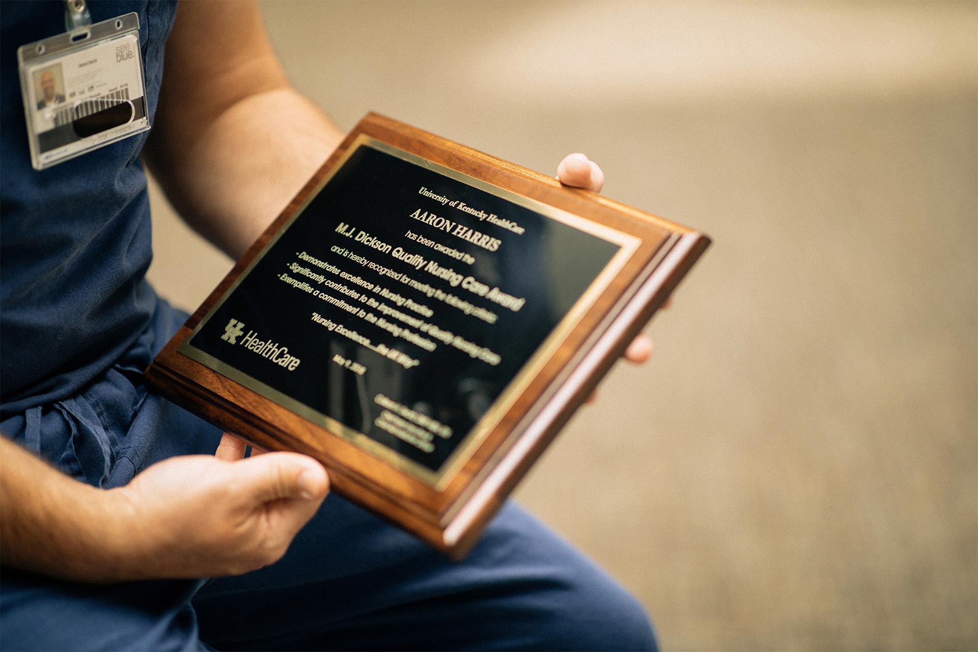 Aaron Harris holding a plaque for a nursing award