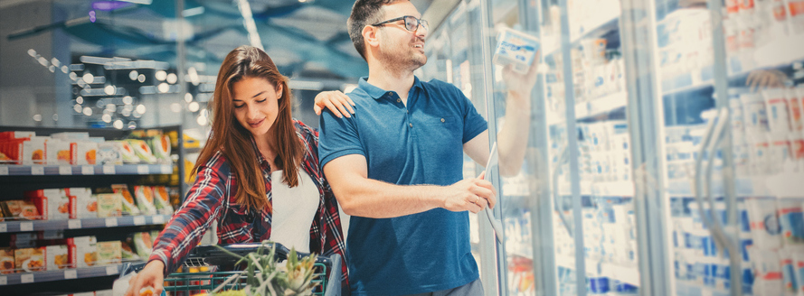 A happy couple grocery shops together.