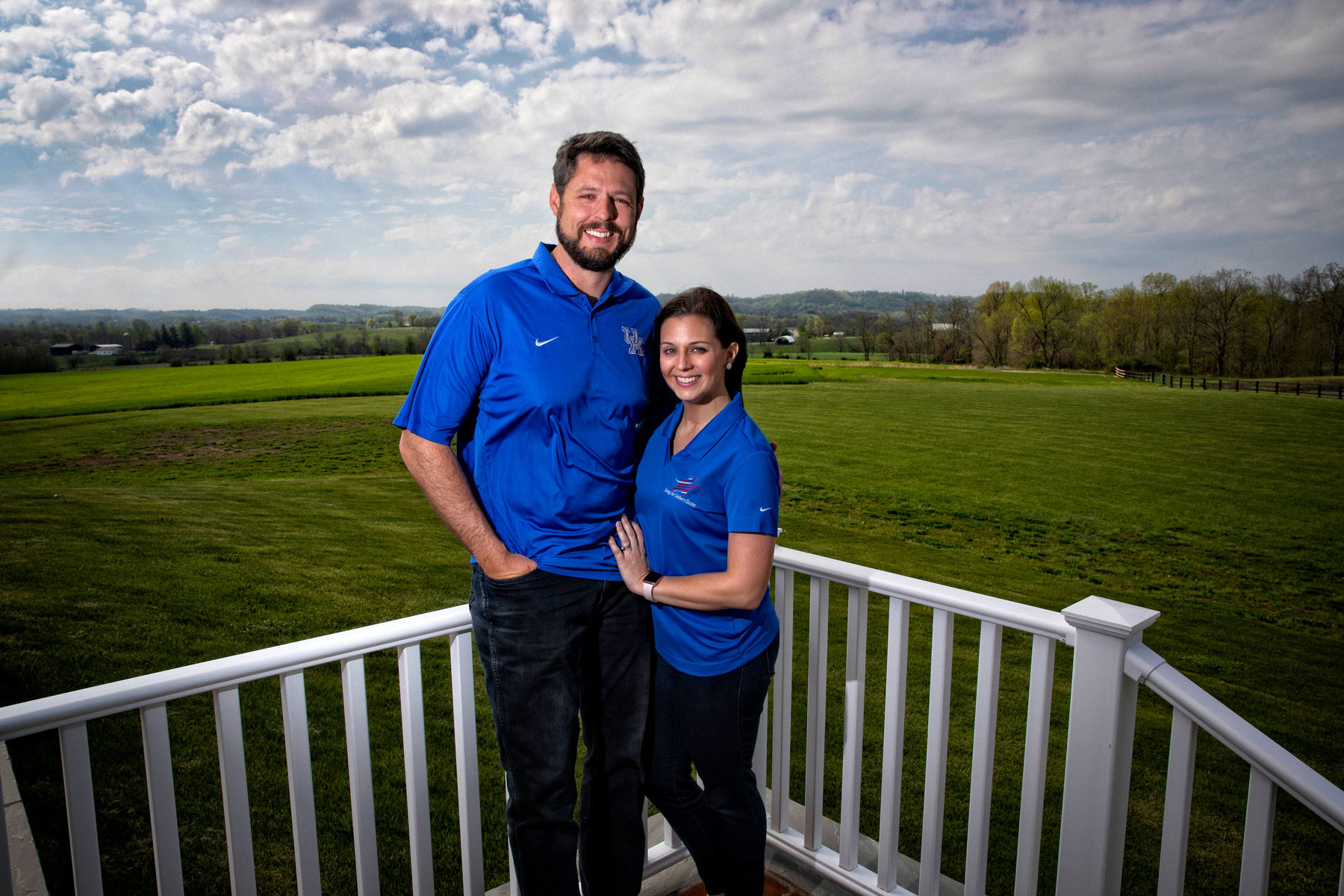 Jacob and his wife Allison lean against their porch railing and smile for a photo.