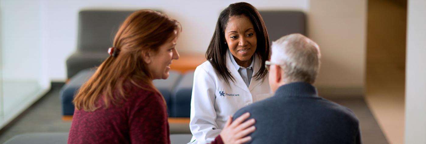 A doctor speaks with a patient and his family member.