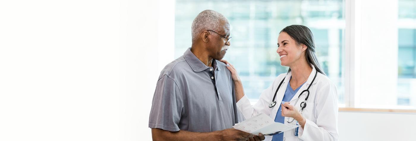 An older man and his doctor, a woman, speak to one another.