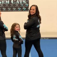 Izzy poses with two of the adult Gem Cat gymnasts.