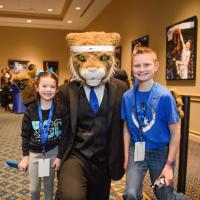 Izzy and Dalton pause for a photo with the UK Wildcat mascot in a suit.