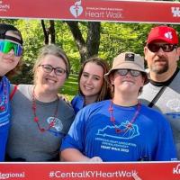 A photo of the entire Mullins family posing together for a photo with a cutout from the American Heart Association’s Heart Walk.