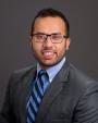 Headshot for Dr. Nakul Natyal from the chest up wearing a grey jacket and blue shirt and striped blue tie